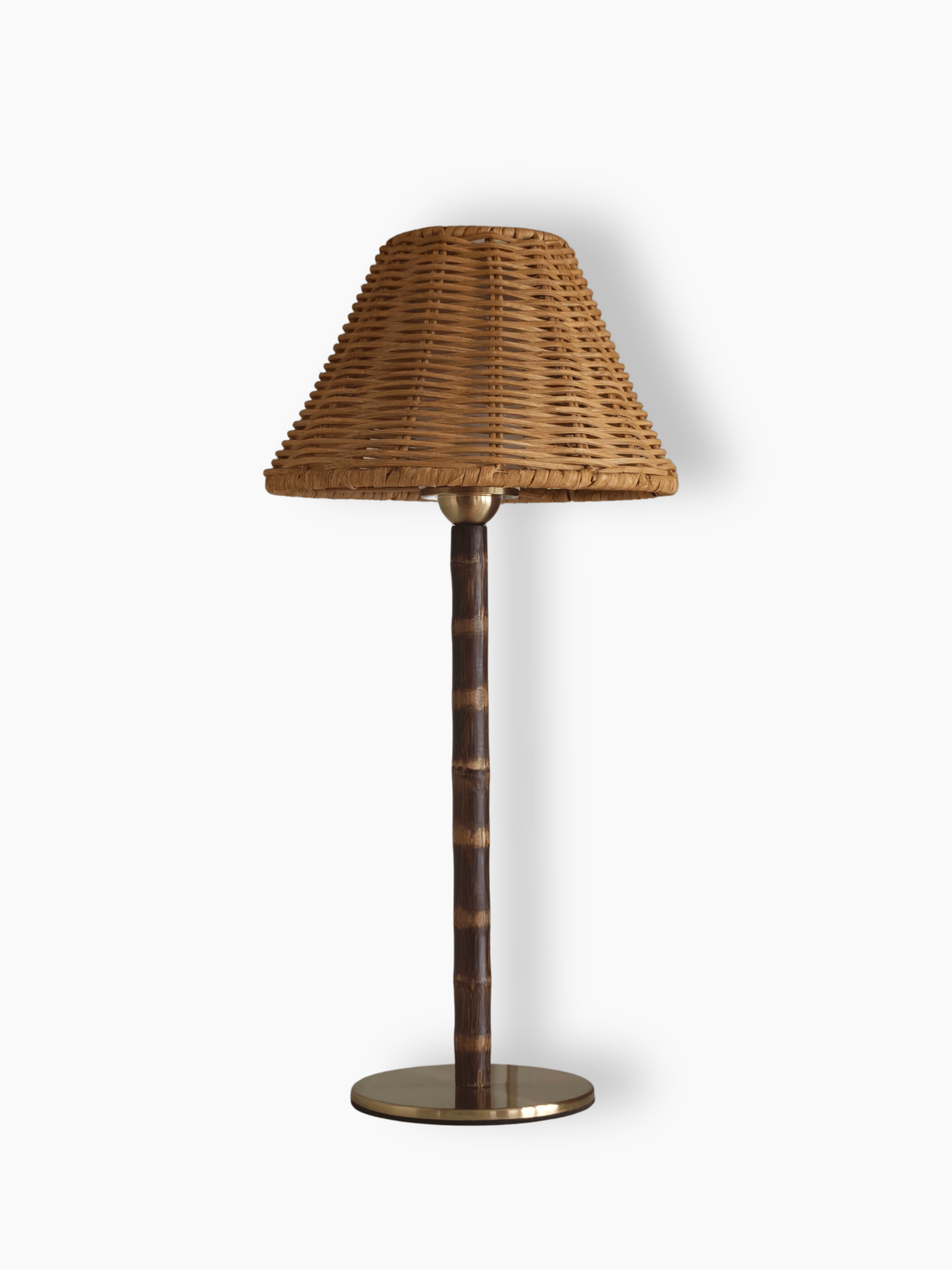 The Raffles cordless table lamp on a white background, showing the wicker shade, bamboo stem and round brass base