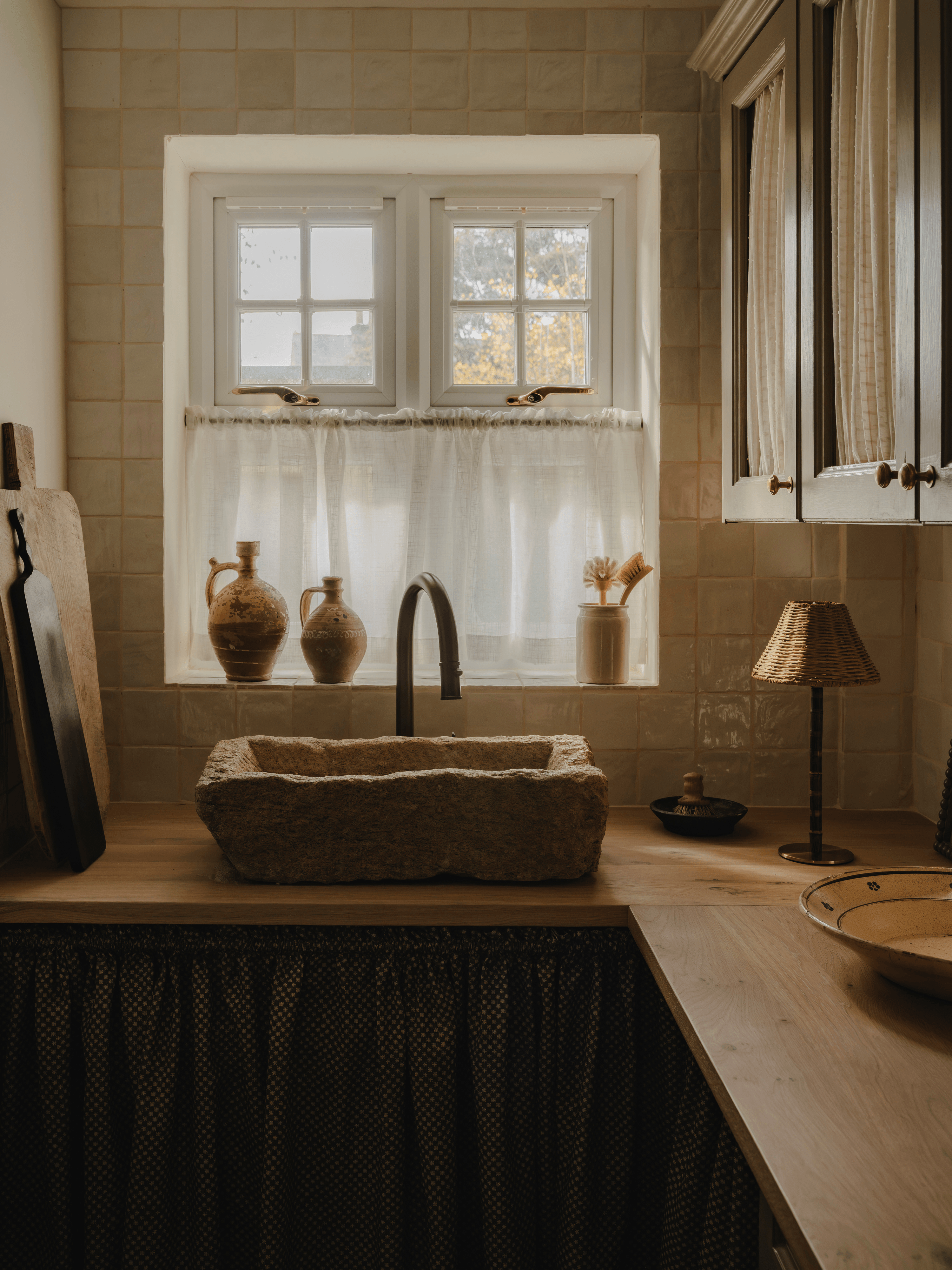 Wide view of a country kitchen with a stone sink, the Raffles rechargeable lamp at the end of the worktop